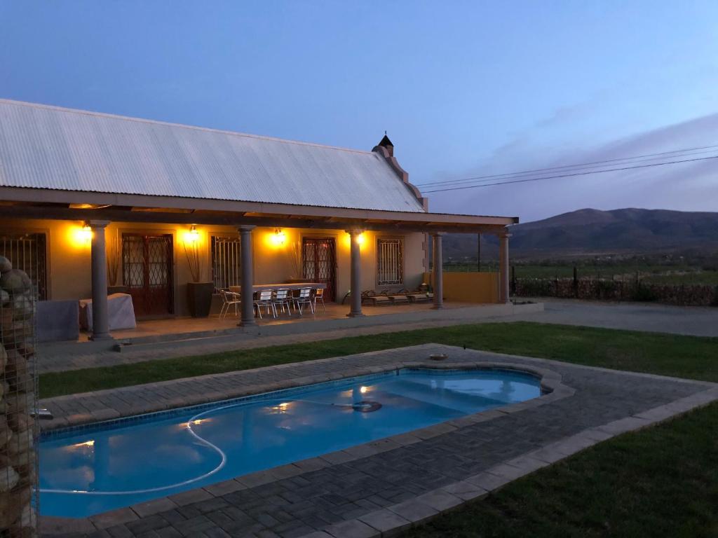 a small swimming pool in front of a house at Celebratio Pomegranate Farm in Oudtshoorn