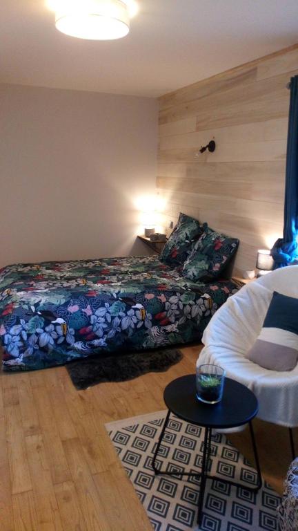 a bedroom with a bed and a couch and a table at L étable au naturel in Mauriac