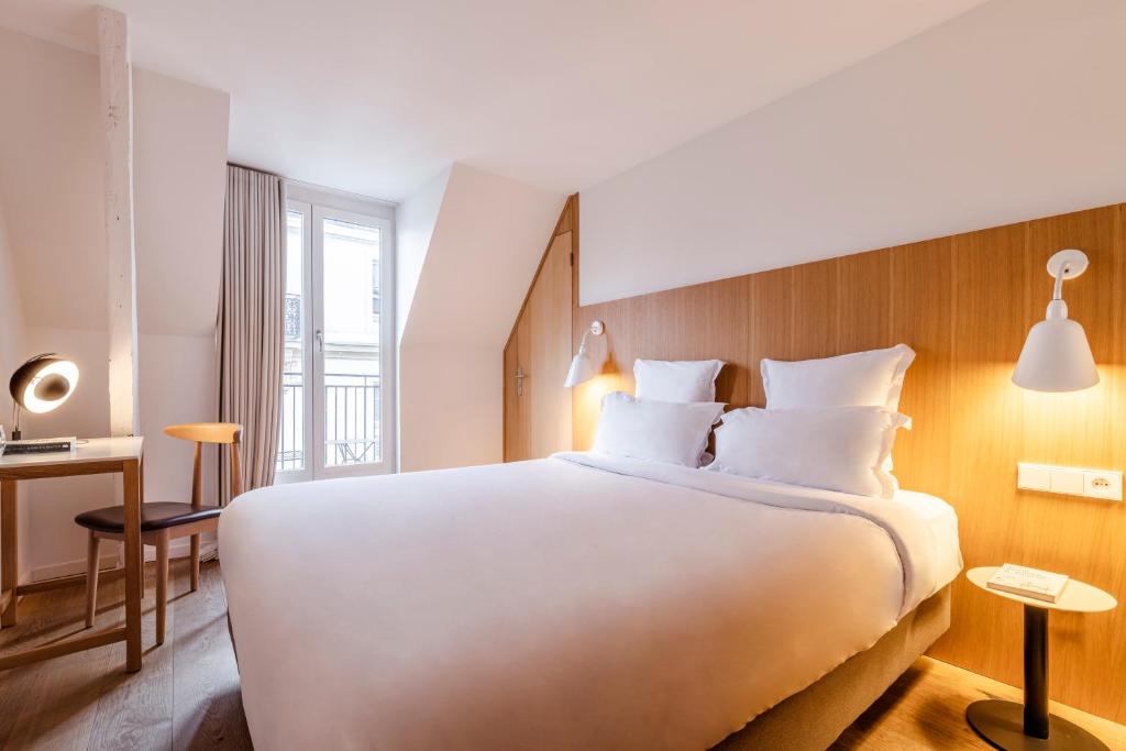 a bedroom with a large white bed and a desk at 9Hotel Republique in Paris