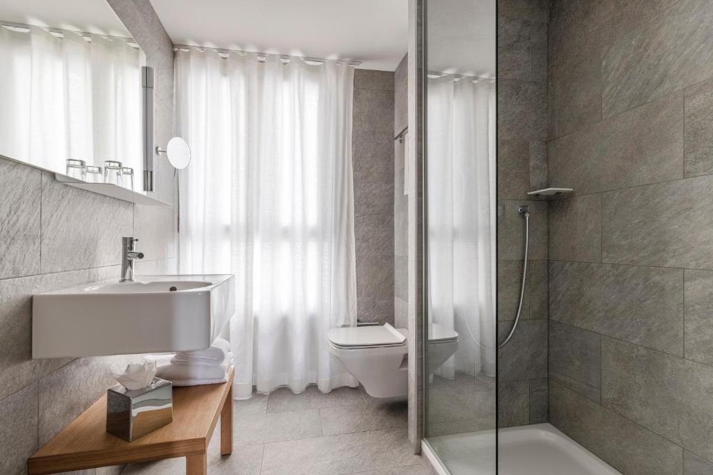 a bathroom with a sink and a toilet and a shower at 9Hotel Republique in Paris