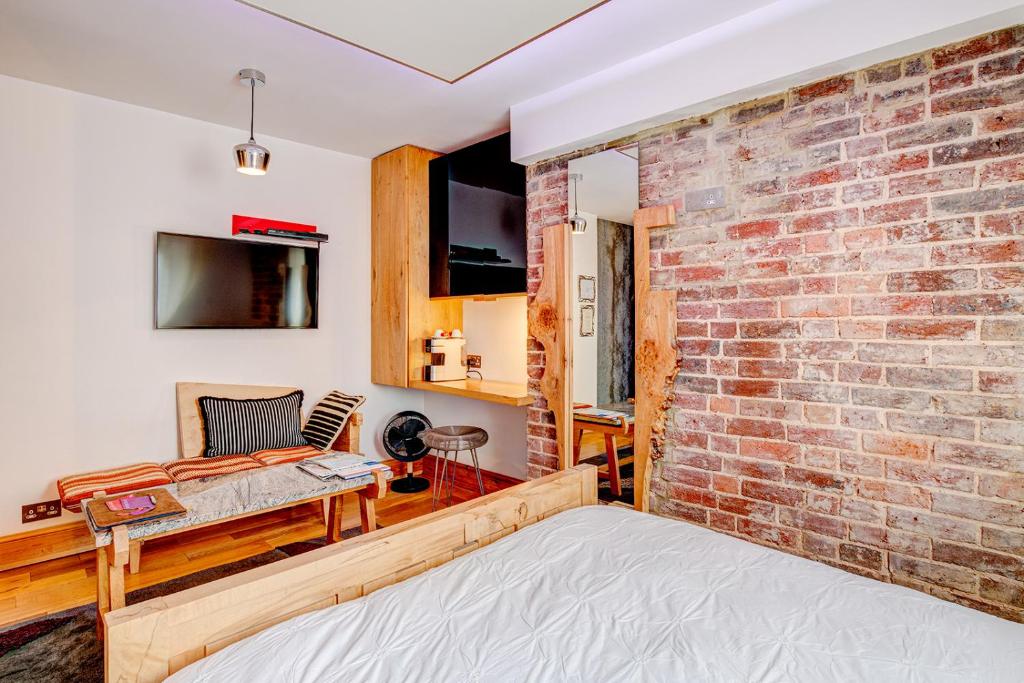 a room with a brick wall and a bed at Hotel Una in Brighton & Hove