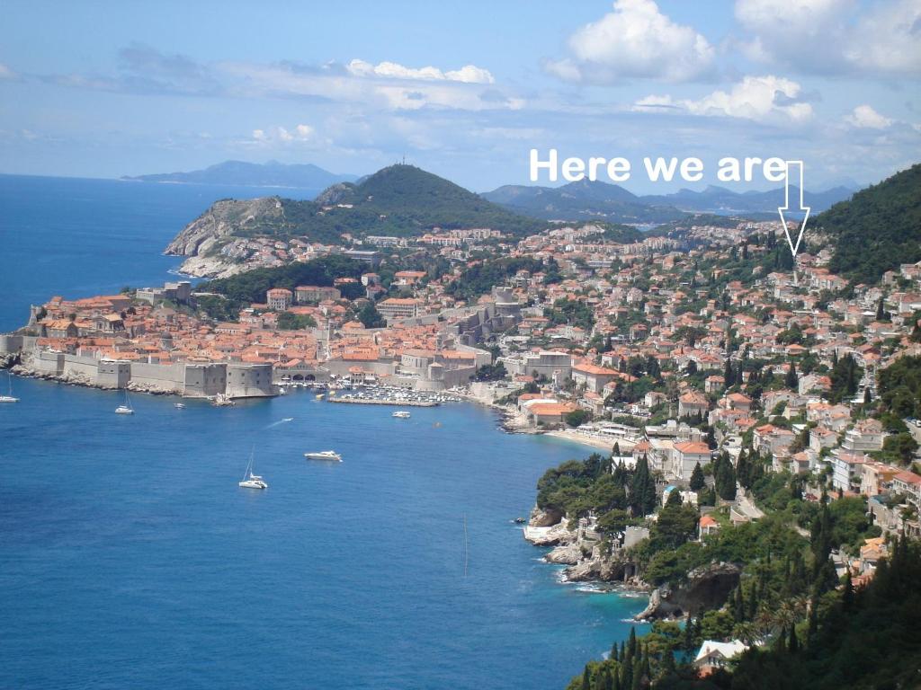 Una vista de una ciudad con las palabras aquí estamos en Apartments Villa Kosović, en Dubrovnik