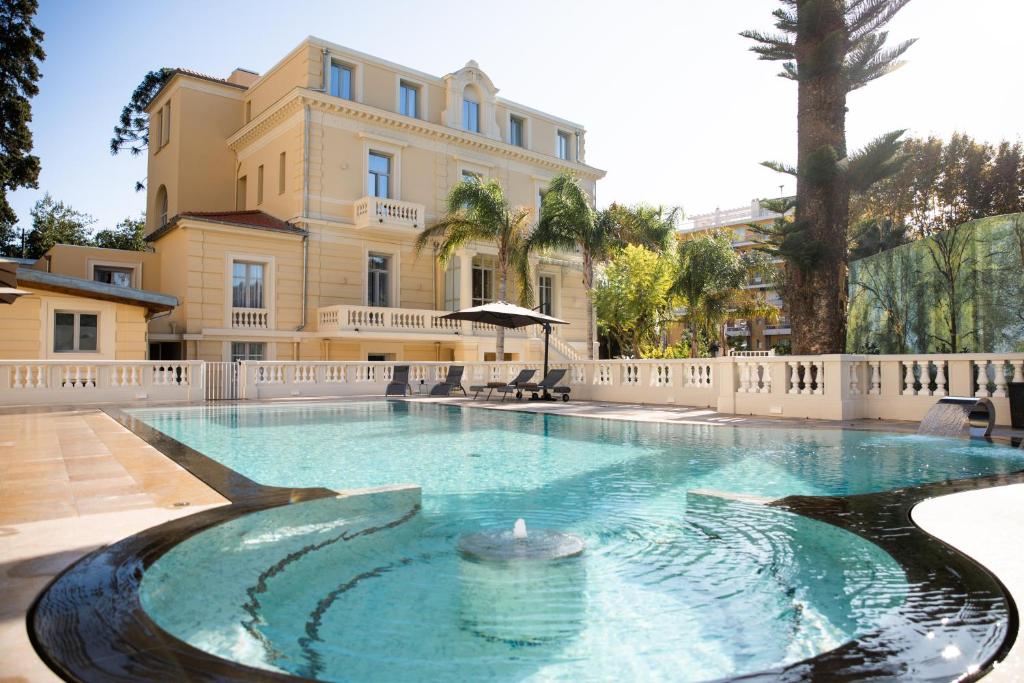 a large swimming pool in front of a building at Villa Genesis in Menton