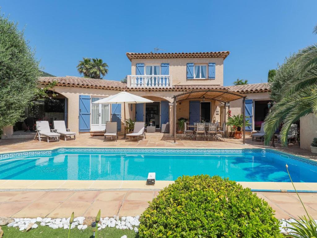 a villa with a swimming pool in front of a house at Holiday Home Villa Souleyas by Interhome in Sainte-Maxime