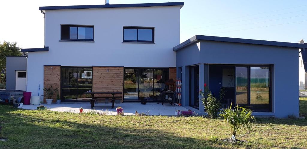 a white house with glass doors on a yard at Locabreizh 22 in Plourivo