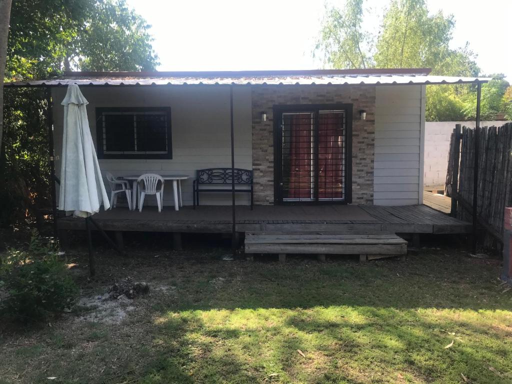 a house with a porch with a table and an umbrella at pequeña casa completa en el pinar in El Pinar