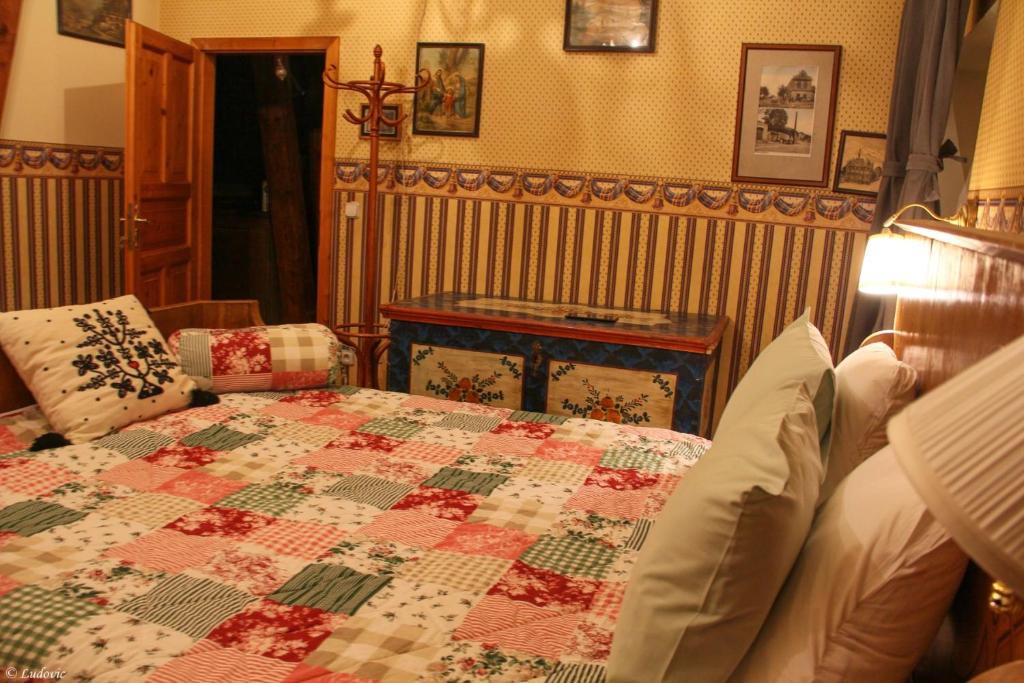 a bedroom with a bed with a quilt on it at Auberge de Provence in Tuchoměřice