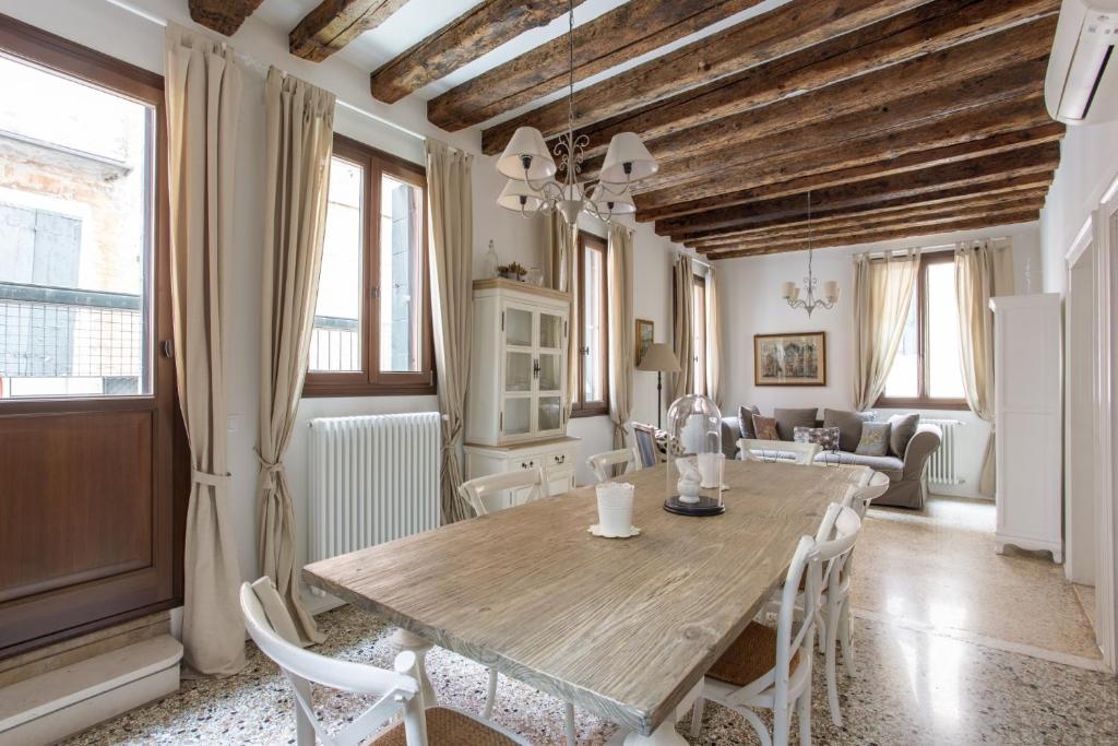 comedor con mesa de madera y sillas en Romantic Rialto, en Venecia