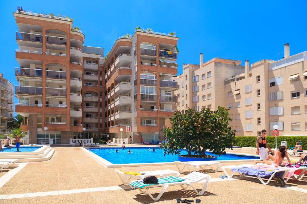 a swimming pool in front of some apartment buildings at UHC CENTER APARTMENTS in Salou