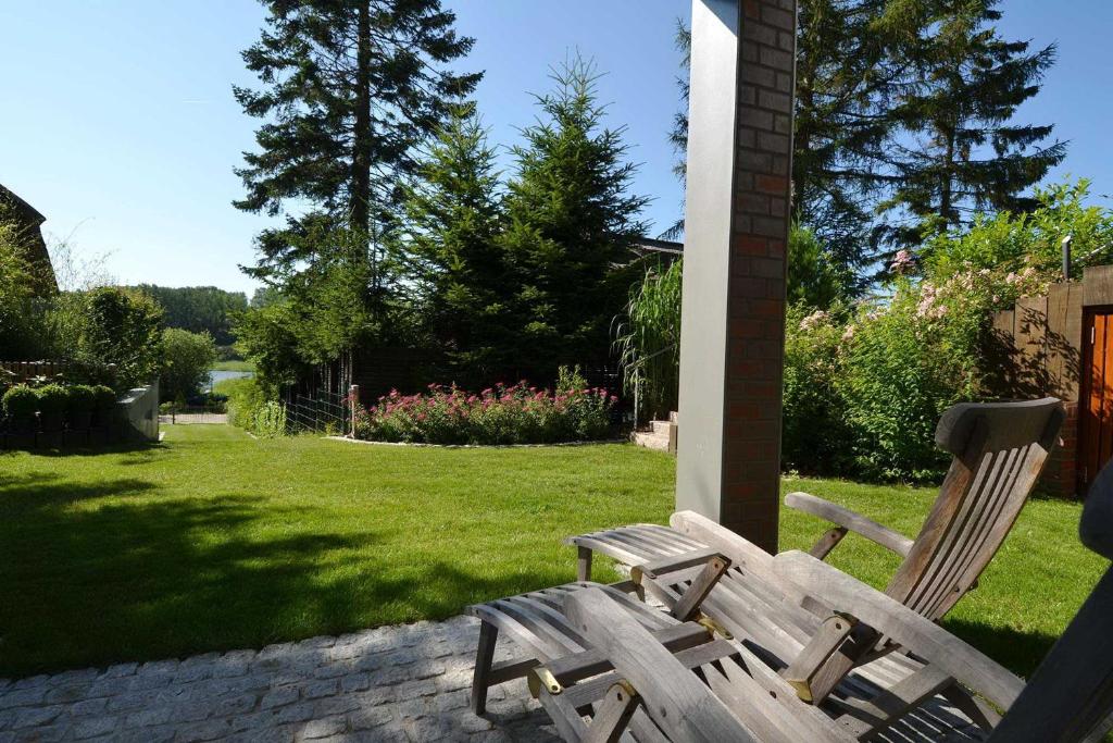 - deux chaises en bois assises dans la cour dans l'établissement Landhaus Gernitz - Ferienwohnung Malerwinkel, à Seedorf