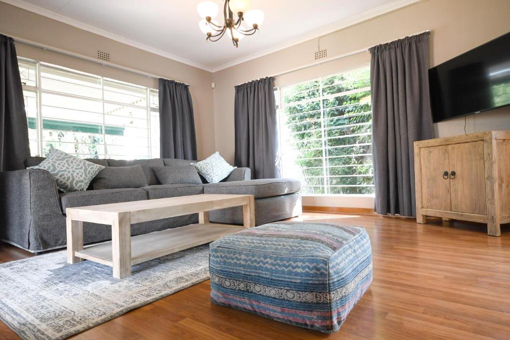sala de estar con sofá y mesa en Linden Gap Guesthouse, en Johannesburgo