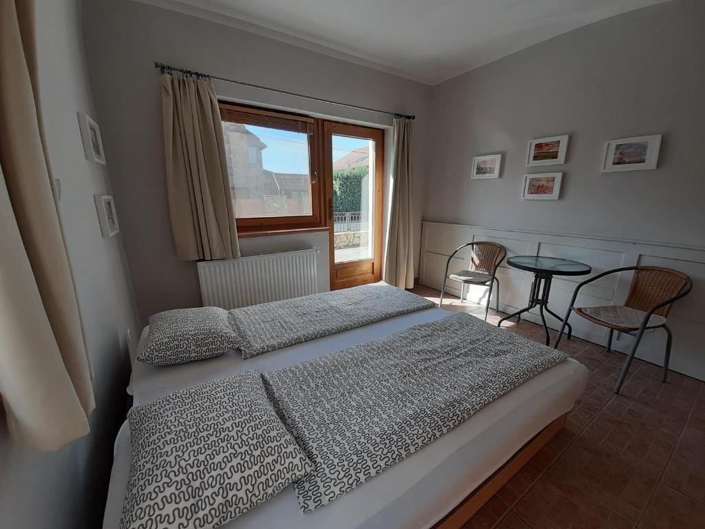 sypialnia z łóżkiem, oknem i stołem w obiekcie Família Apartmanház w mieście Keszthely