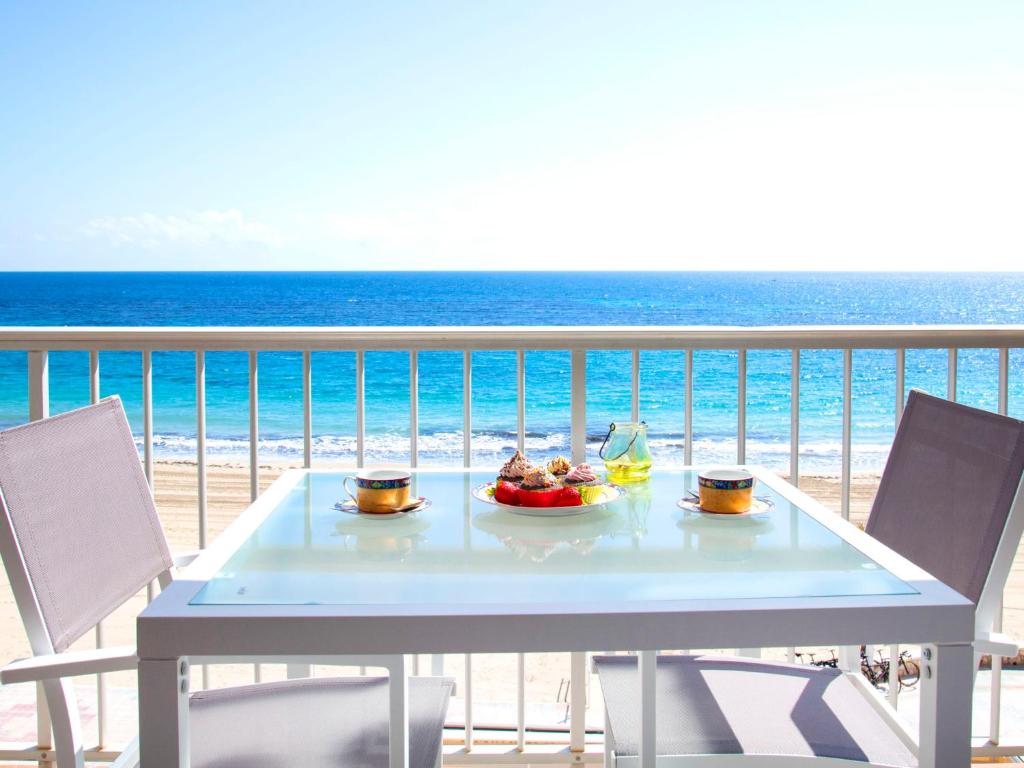 uma mesa com uma tigela de fruta numa varanda com praia em Apartment Primum by Interhome em Calpe
