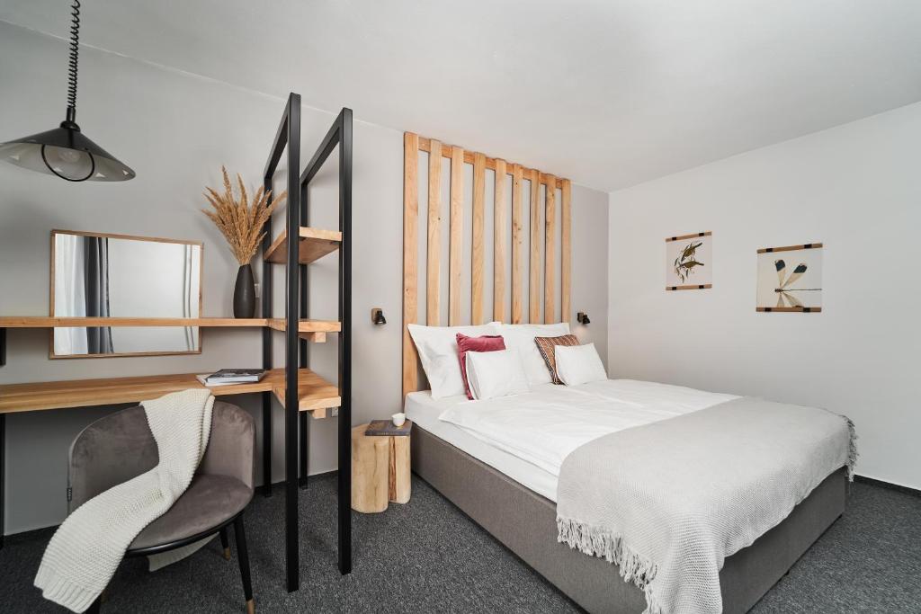 Un pat sau paturi într-o cameră la Hotel Arborétum