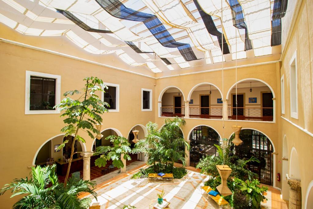 une cour intérieure avec un plafond planté d'arbres et de plantes dans l'établissement Hotel Merida, à Mérida