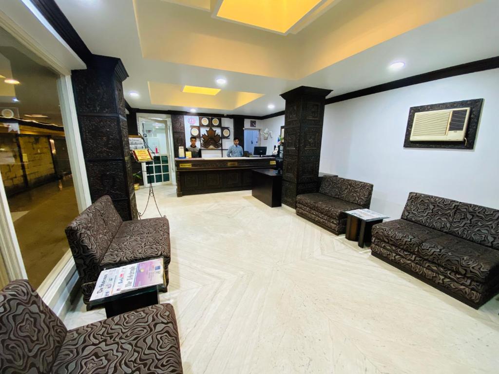 una sala de espera con 2 sillas y un mostrador en Saluja Residency en Siliguri