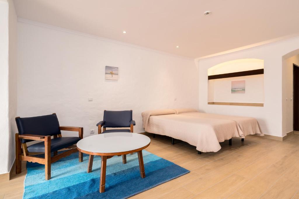 - une chambre avec un lit, deux chaises et une table dans l'établissement Apartamentos Borda D´Agua, à Albufeira