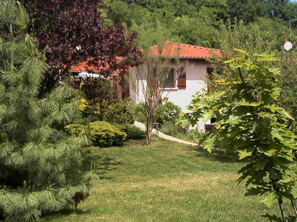 un jardin avec une maison en arrière-plan dans l'établissement La Meïzou, gîte - chambres d hôtes à Champeix, à Champeix