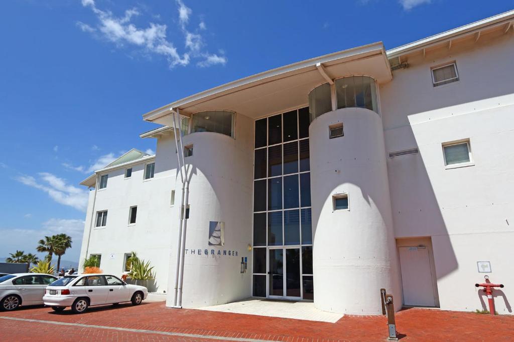 a white building with a car parked in front of it at Granger Luxury Suites by Totalstay in Cape Town