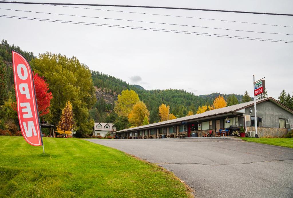 a stop sign in the grass next to a building at Lakeview Motel in Christina Lake