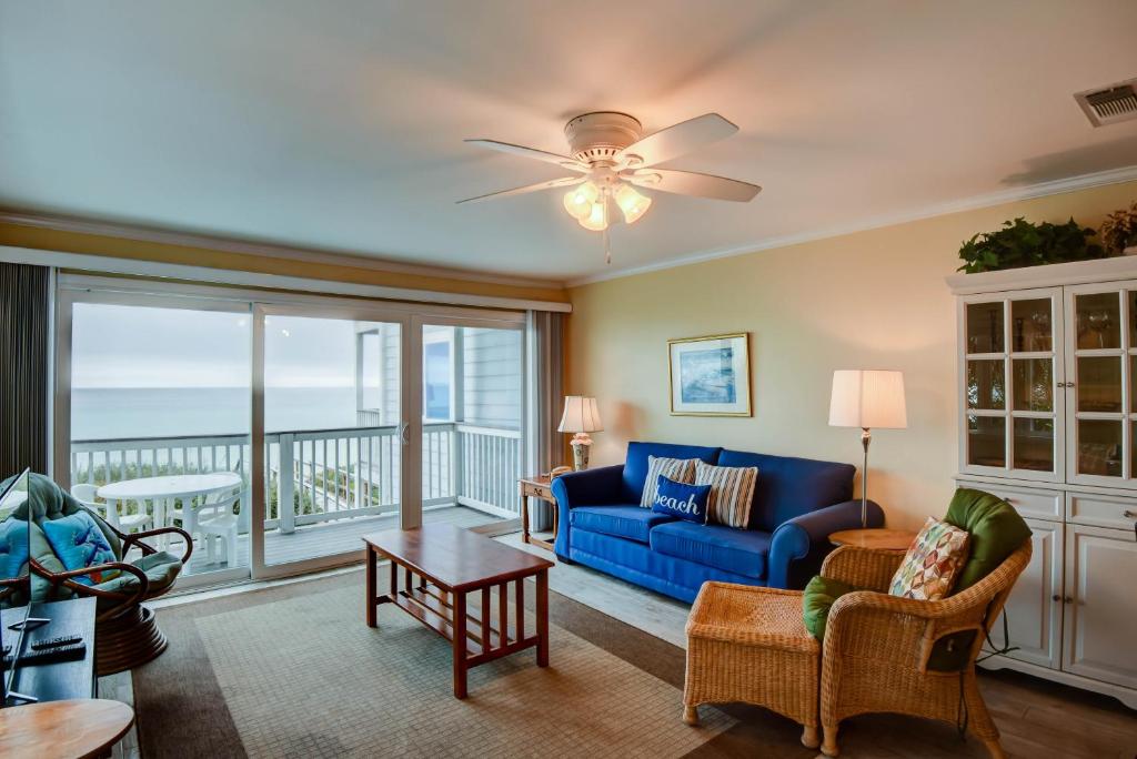 a living room with a blue couch and a balcony at Ramsgate 4 in Seacrest
