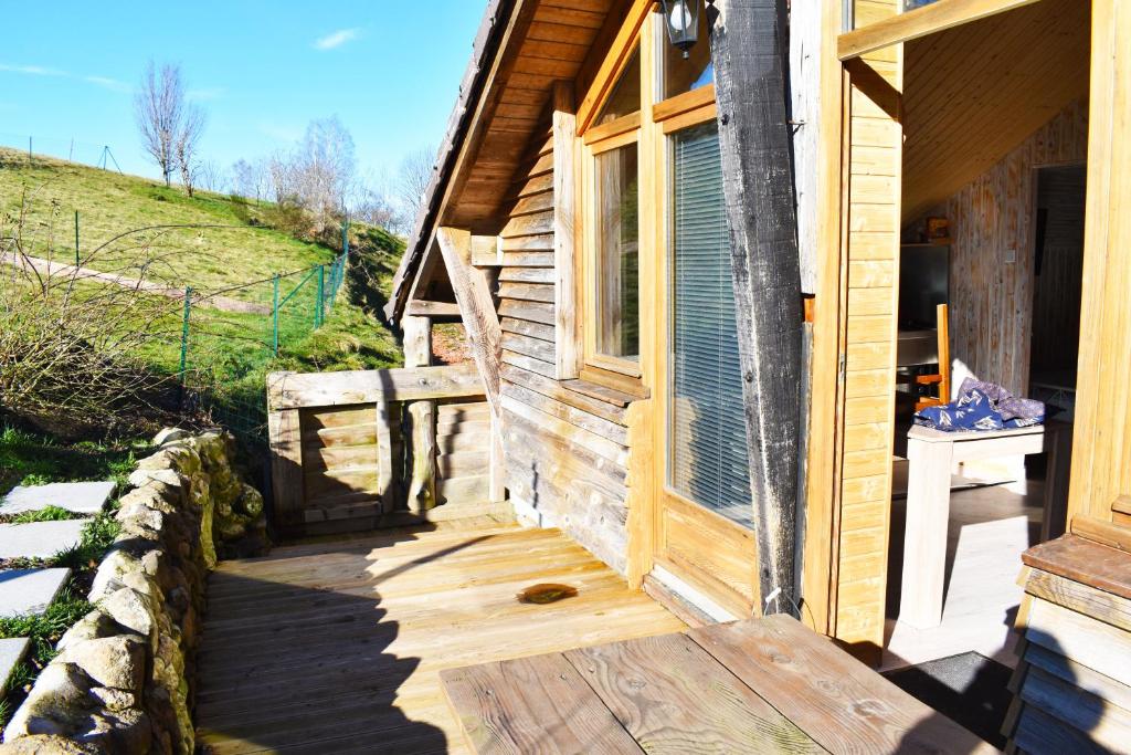 un porche de una casa de madera con ventana en "La vieille Grange", au coeur de la nature, en Laveline-du-Houx