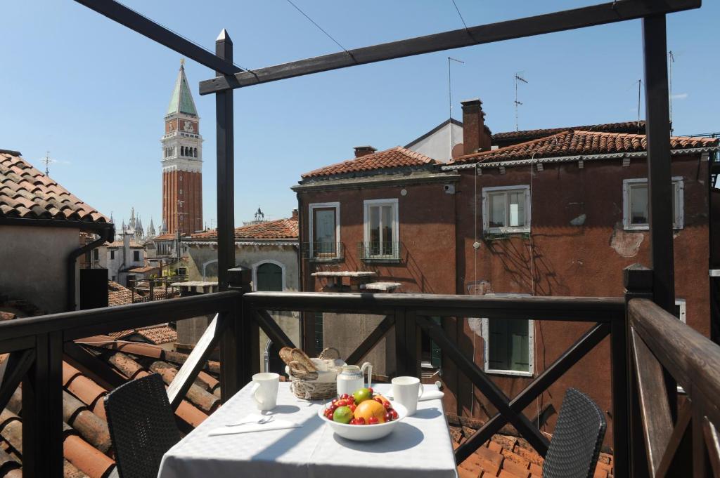 eine Schale mit Obst auf einem Tisch auf einem Balkon in der Unterkunft TRA SAN MARCO E RIALTO in Venedig
