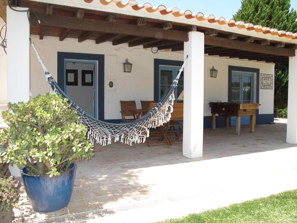 a patio with a hammock and a house at Monte da Cascalheira in Porto Covo