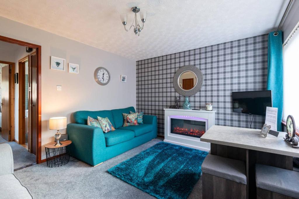 a living room with a blue couch and a fireplace at towerhill in Culloden