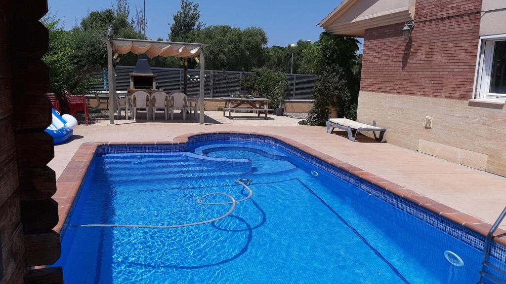 ein blauer Pool mit einem Schlauch im Hof in der Unterkunft VILLA FLOR in Cambrils