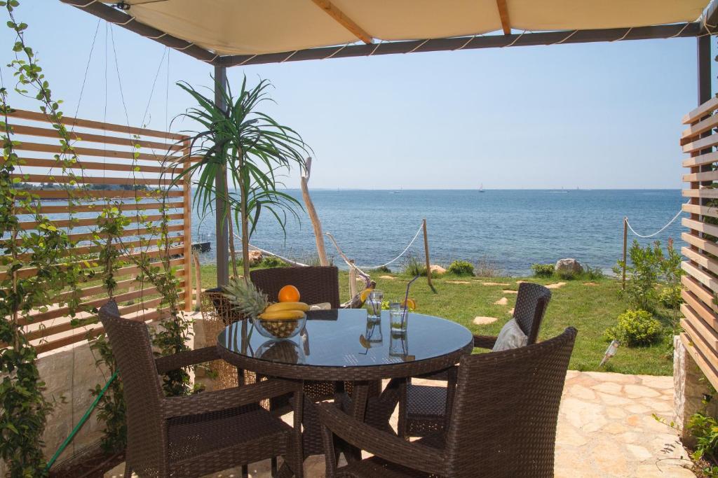 una mesa y sillas en un patio con vistas al océano en Apartments Erica Luxury, en Novigrad Istria