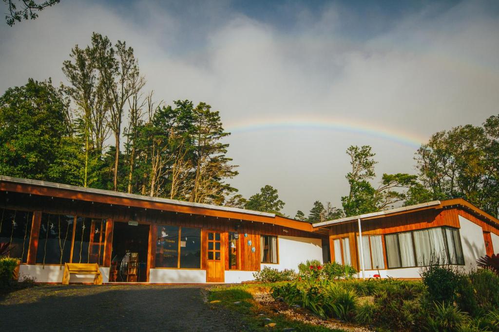 Ein Haus mit Regenbogen am Himmel in der Unterkunft Hotel Holístico Monteverde in Monteverde Costa Rica