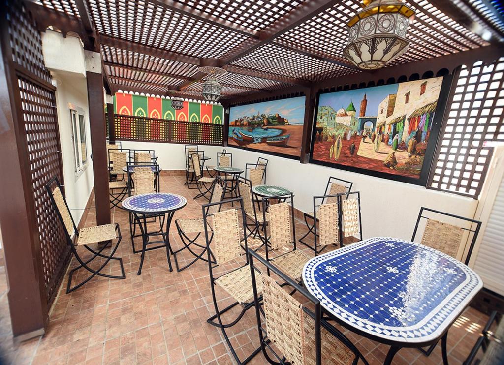a restaurant with tables and chairs and paintings on the wall at Riad Dar El Mesk in Rabat