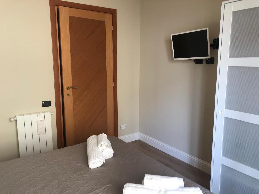sypialnia z ręcznikami na łóżku z telewizorem w obiekcie GISELLE HOUSE w Cagliari