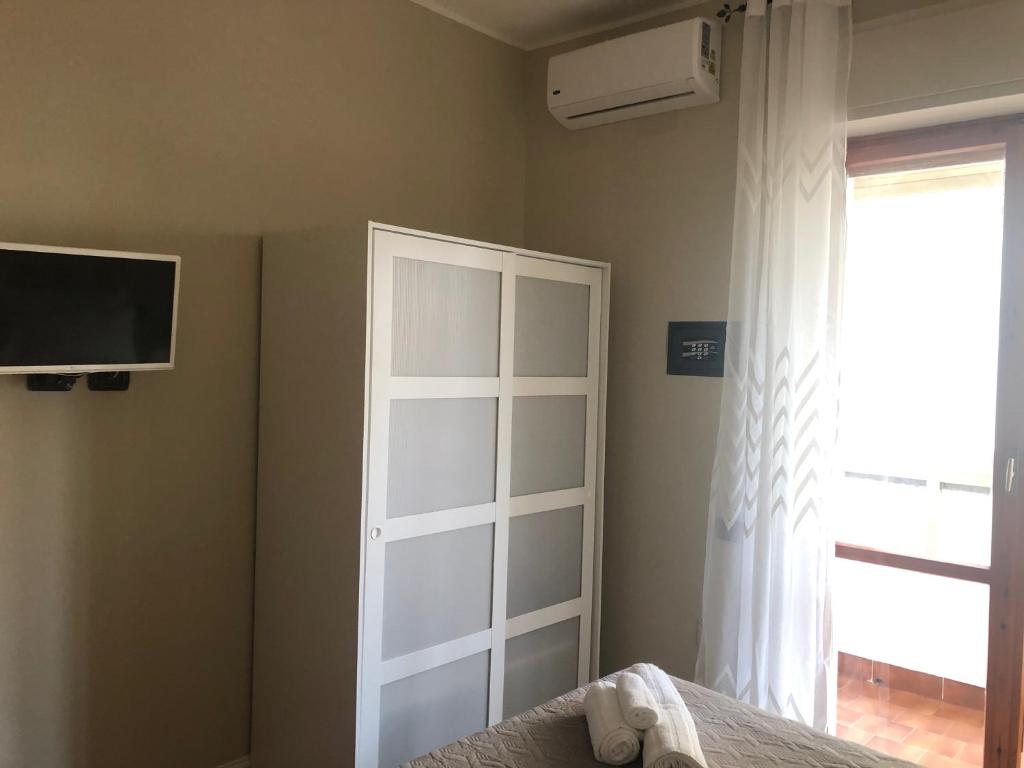sypialnia z białymi drzwiami i oknem w obiekcie GISELLE HOUSE w Cagliari