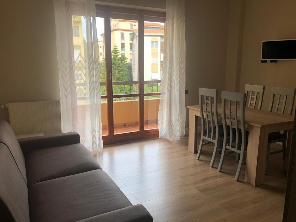 salon z kanapą i stołem z krzesłami w obiekcie GISELLE HOUSE w Cagliari