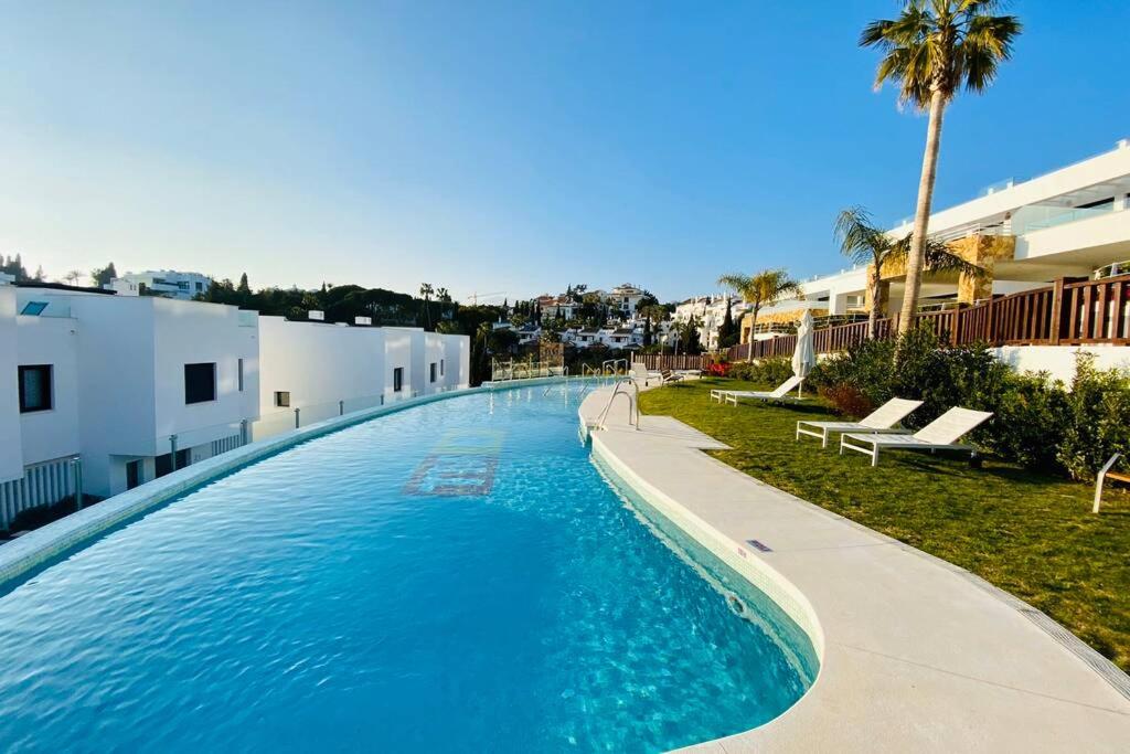 duży basen obok niektórych budynków w obiekcie Amazing Exclusive House in Marbella Golden Mile w Marbelli