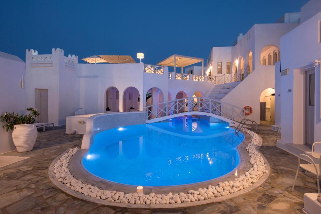 a large swimming pool in the middle of a house at Kanale's Rooms & Suites in Naousa