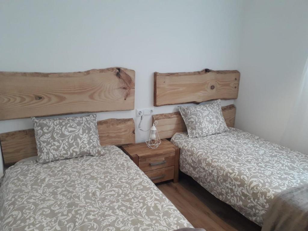 a bedroom with two beds and a wooden headboard at Céntrico y con encanto en tierra de vinos in Logroño