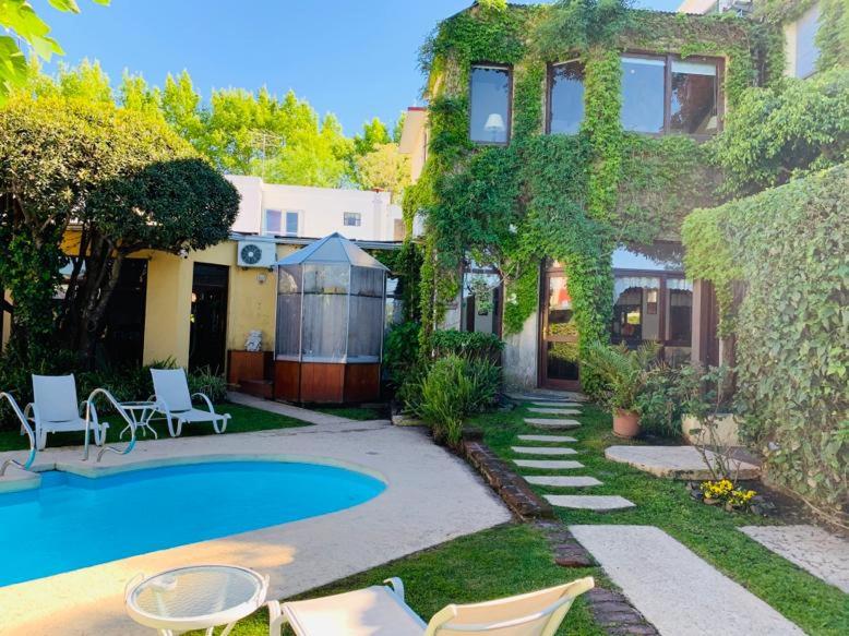 un patio con piscina y una casa en Posada del Angel, en Colonia del Sacramento