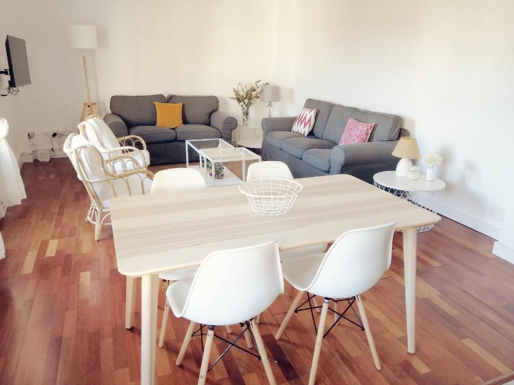 a living room with a table and white chairs at Singular Ronda Apartment in Ronda