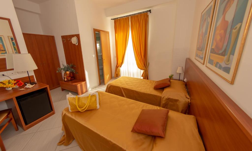 a hotel room with two beds and a television at Hotel Solaria in Rodi Garganico