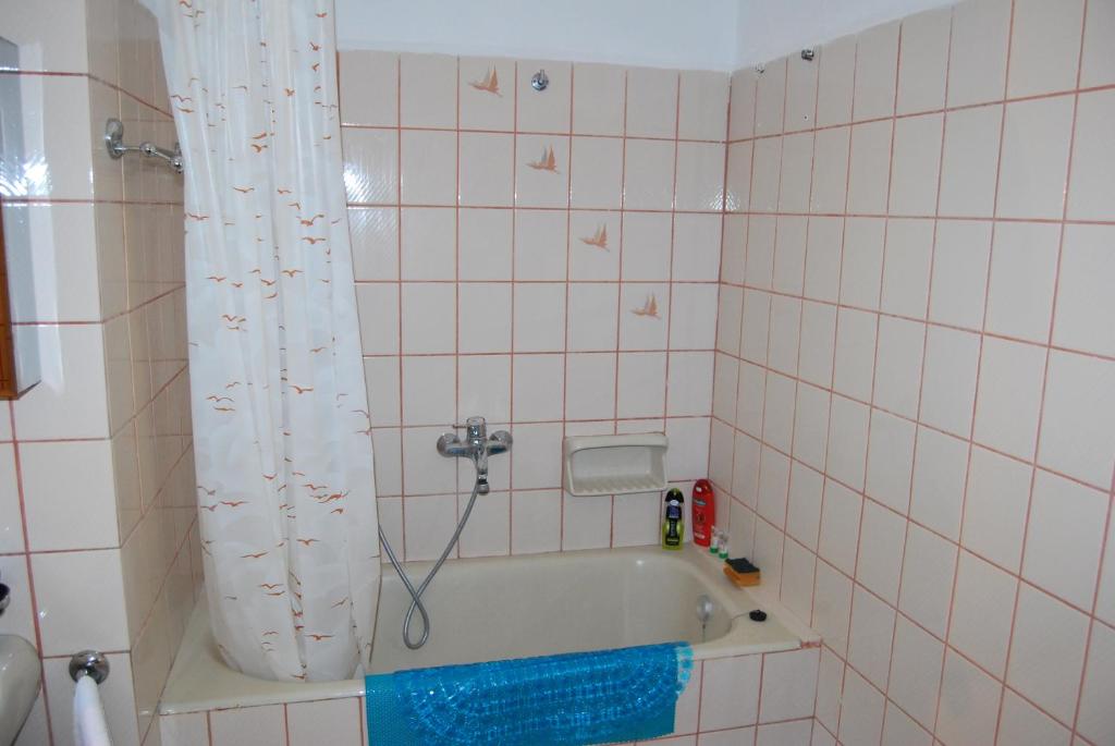 a bathroom with a bath tub with a shower curtain at Ktima Garidis in Kavála