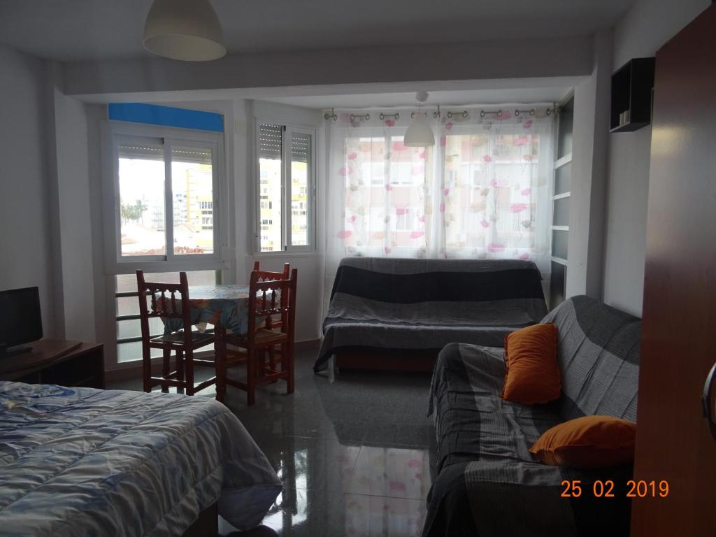 1 dormitorio con 2 camas, mesa y sillas en Estudio Plazamar, en Torre del Mar