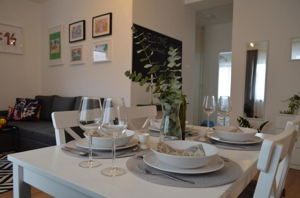 a dining room table with wine glasses and a white table cloth at Apartman 19:14 in Bjelovar