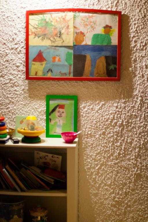 a shelf with paintings on the wall and a shelf with bowls at Mare Vista Hotel - Epaminondas in Batsi