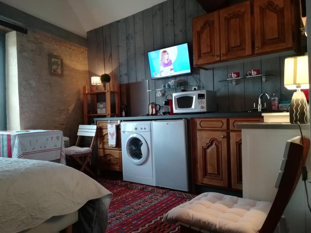 a kitchen with a washing machine and a microwave at The Good Studio Vezelay in Vézelay