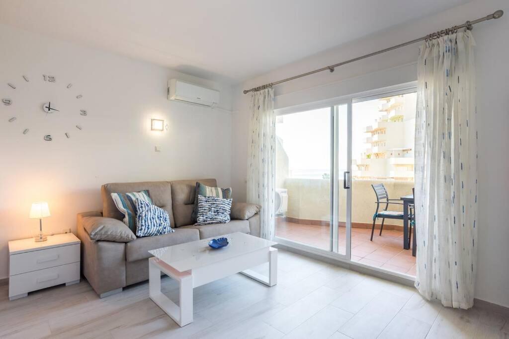 salon z kanapą i stołem w obiekcie Sol Apartment - C&G Benal Beach w mieście Benalmádena