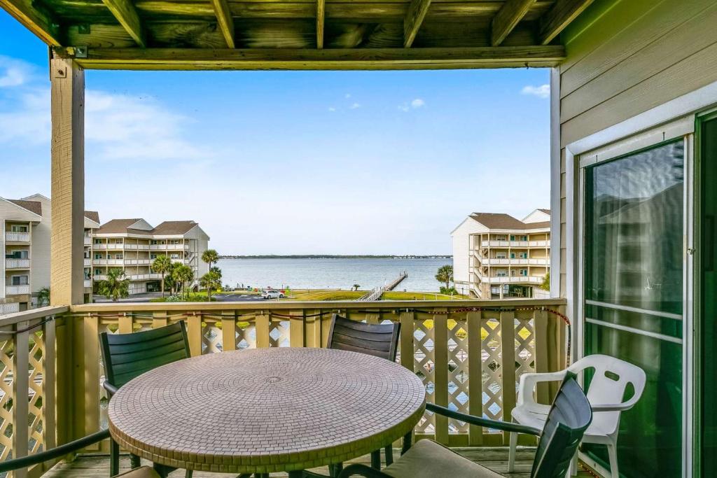 a balcony with a table and chairs and a view of the water at Baywatch A8 in Pensacola Beach