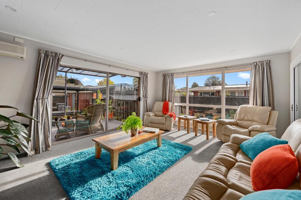 uma sala de estar com um sofá e uma mesa em Leave of Absence - Christchurch Holiday Home em Christchurch